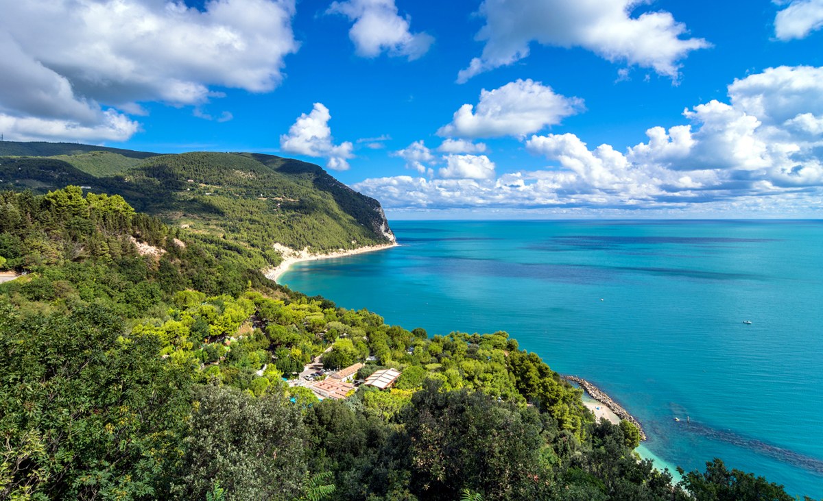 Turquoise Mediterranean cove framed by cliffs on the Italian coast